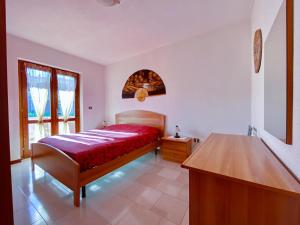 1 dormitorio con cama y mesa de madera en Casa costa Smeralda R5875, en Monte Petrosu