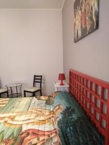 una camera da letto con un letto e un dipinto sul muro di Domus Musia a Milazzo