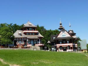 ein großes Haus mit zwei Türmchen auf einem grünen Feld in der Unterkunft Penzion Silverado in Horní Bečva