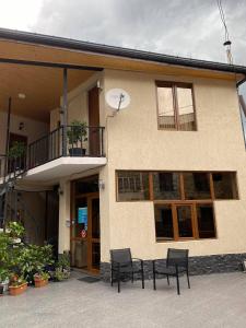 a building with two chairs and a table in front of it at Guest House Nikala in Mestia