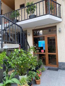 a building with a staircase and plants in front of it at Guest House Nikala in Mestia