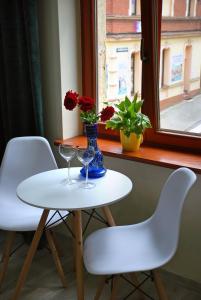 una mesa con dos copas de vino y un jarrón con flores en Apartament - Przy Rynku en Tarnowskie Góry