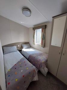 a small bedroom with two beds and a window at Vault 21 in Millom