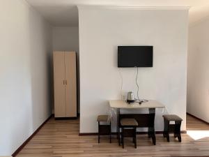 a room with a table with chairs and a tv on a wall at Delfin Murok in Bosteri