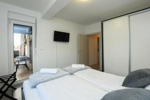- une chambre avec un lit et une télévision murale dans l'établissement Apartman Klara, à Kladovo