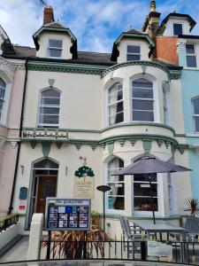 un edificio con una sombrilla delante de él en Glascoed Guest House, en Llandudno