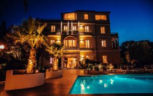 a large house with a swimming pool in front of it at Hotel Benaco in Desenzano del Garda +115 photos