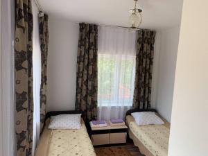 a small room with two beds and a window at Delfin Murok in Bosteri