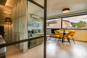 a room with a table and chairs and a couch at Muse Urban Suites in Athens