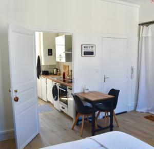 uma cozinha com mesa e cadeiras num quarto em Le Studio de Meli, 3 étoiles, 30m2, raffiné, élégant et bien situé em Rochefort