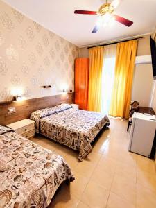 a bedroom with two beds and a ceiling fan at Bed & Breakfast Delle Palme in Trapani