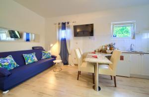 un soggiorno con divano blu e tavolo di Apartment Nena a Krk