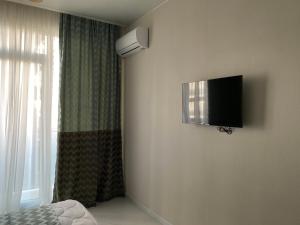 a bedroom with a flat screen tv on the wall at Horizons Hotel Rooms in Batumi