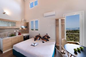 a bedroom with a bed and a table and a window at Vista Del Diamante Apartments in Apolpaina