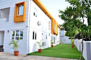 una casa con un césped verde delante de ella en Orange Roof Lodge, en Abuja