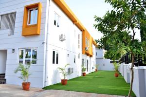 une maison avec une pelouse verte devant elle dans l'établissement Orange Roof Lodge, à Abuja