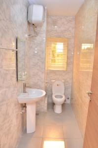 La salle de bains est pourvue de toilettes et d'un lavabo. dans l'établissement Orange Roof Lodge, à Abuja