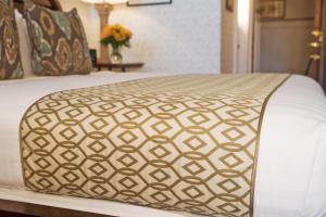 a bed with a gold and white comforter at Elizabeth Pointe Lodge in Fernandina Beach