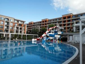 a water slide in the middle of a swimming pool at Sea View Apartment PRESTIGE FORT BEACH , PREMIER FORT BEACH in Sveti Vlas
