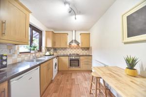 eine Küche mit Holzschränken und einer hölzernen Arbeitsplatte in der Unterkunft Belle Cottage in Ashbourne