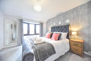 a bedroom with a large bed with orange pillows at Belle Cottage in Ashbourne