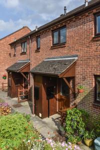 ein großes Backsteingebäude mit zwei Garagen in der Unterkunft Belle Cottage in Ashbourne