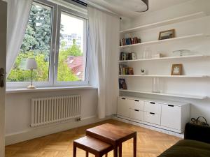 a living room with a table and a window at Chic Apartment in vibrant area - National Stadium - Saska Kępa in Warsaw