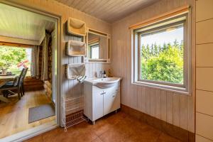 a bathroom with a sink and a window at Huusi Holiday in Hellamaa