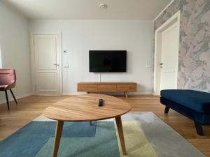 a living room with a coffee table and a tv at Niidupuu Apartment in Kuressaare