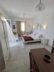 a bedroom with a bed and a table at Vitzileos Studios in Agios Prokopios