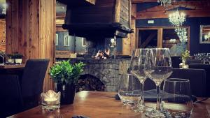 una mesa con copas de vino y una chimenea en un restaurante en La Perelle, en Saint-François-Longchamp