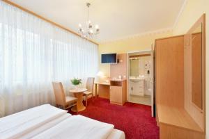 a hotel room with a bed and a dresser at Garten- und Kunsthotel Gabriel City in Vienna