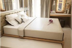 a large white bed with a flower on top of it at Cosmy Orchard Apartment at Pakuwon Mall with Wifi in Surabaya