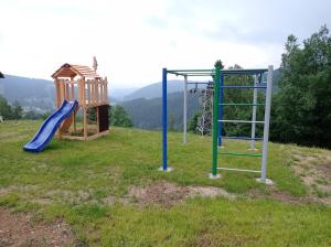 two childrens playground equipment in a field at apartmány Kynast in Albrechtice v Jizerských horách