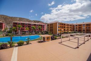an apartment complex with a swimming pool and buildings at Beatriz del Mar - Apartamento con aire acondicionado in Palm-Mar