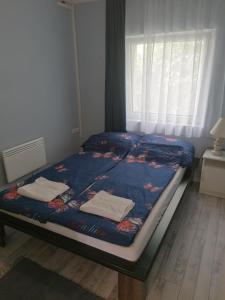 ein Bett mit zwei Handtüchern darauf in einem Schlafzimmer in der Unterkunft Aleksandros in Mezőkövesd