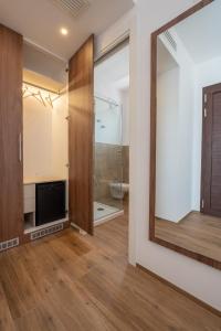 uma casa de banho com um chuveiro e um espelho. em Elaia Rooms em Noto Marina