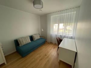 - un salon avec un canapé bleu et une fenêtre dans l'établissement Niidupuu Apartment, à Kuressaare