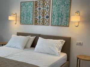 1 cama con 2 almohadas y 2 pinturas en la pared en Margarita Guesthouse, en Apollonia