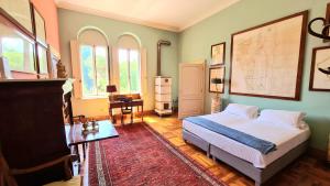 a bedroom with a bed and a table and windows at Castello di Lispida in Monselice
