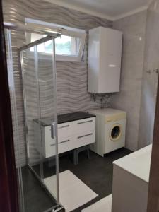 a small kitchen with a washing machine and a washer at Arnika Vendégház in Hajdúszoboszló +27 photos