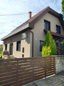 a house with a wooden fence in front of it at Arnika Vendégház in Hajdúszoboszló
