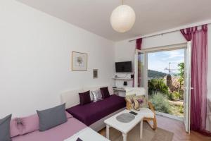 uma sala de estar com um sofá roxo e uma mesa em Apartment Purple Rain em Dubrovnik