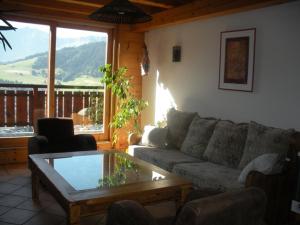 a living room with a couch and a coffee table at Chalet L' Irrawaddy in Megève +7 photos