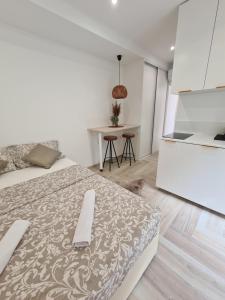 een witte slaapkamer met een bed en een keuken bij Balance apartments in Koper