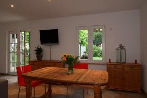 - un salon avec une table en bois et un vase de fleurs dans l'établissement Ferienhaus an der Plantage, à Dresde
