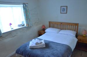 a bedroom with a bed with towels on it at The Royal Oak Inn in Dunsford