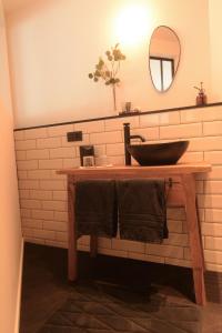 een badkamer met een houten wastafel en een spiegel bij B&B Miranoza in Oud-Heverlee