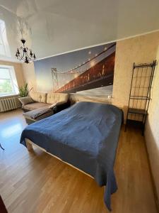 ノヴォロシースクにあるКвартира на улице Мира 45のベッドルーム1室(ベッド1台付)が備わります。壁には橋の絵画が飾られています。