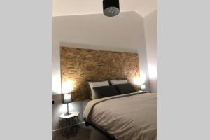 1 dormitorio con 1 cama grande y 2 lámparas en Appartement Loft dans domaine historique d'exception en Vernaison